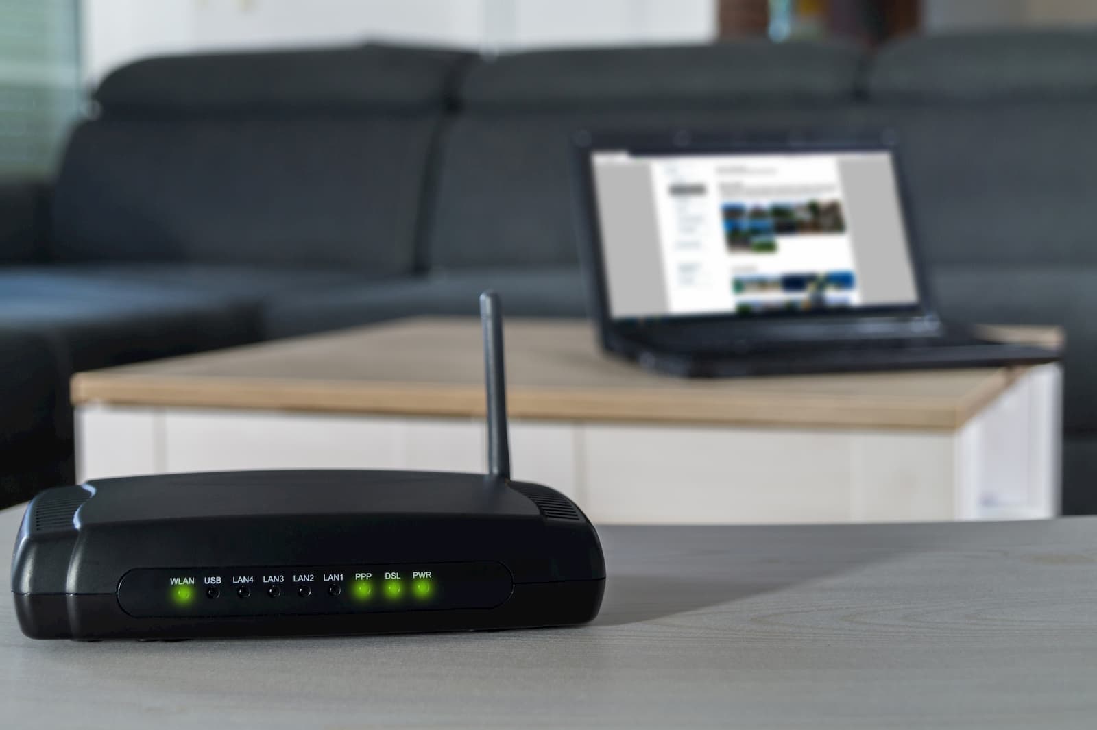 router sitting on a table near a laptop